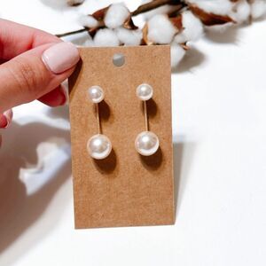 Double pearl drop earrings .
